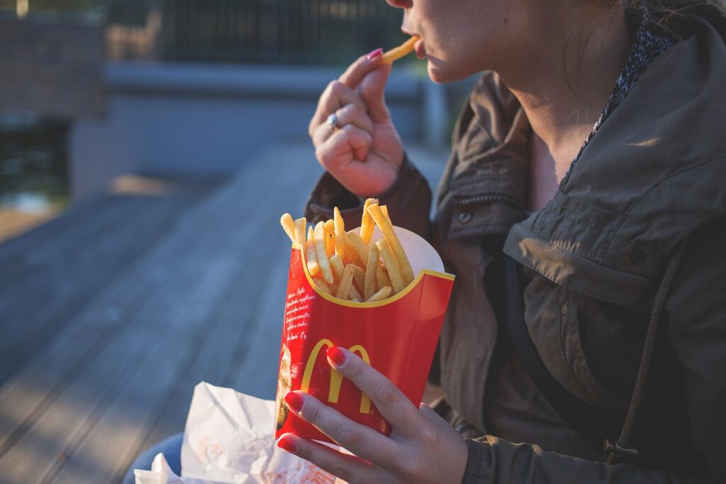 Mulher comendo Fast-Food.