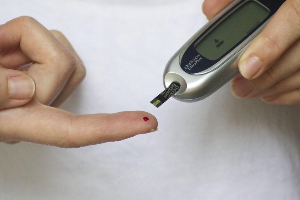 Colocando o dedo com uma gotinha de sangue no equipamento para medir a glicose